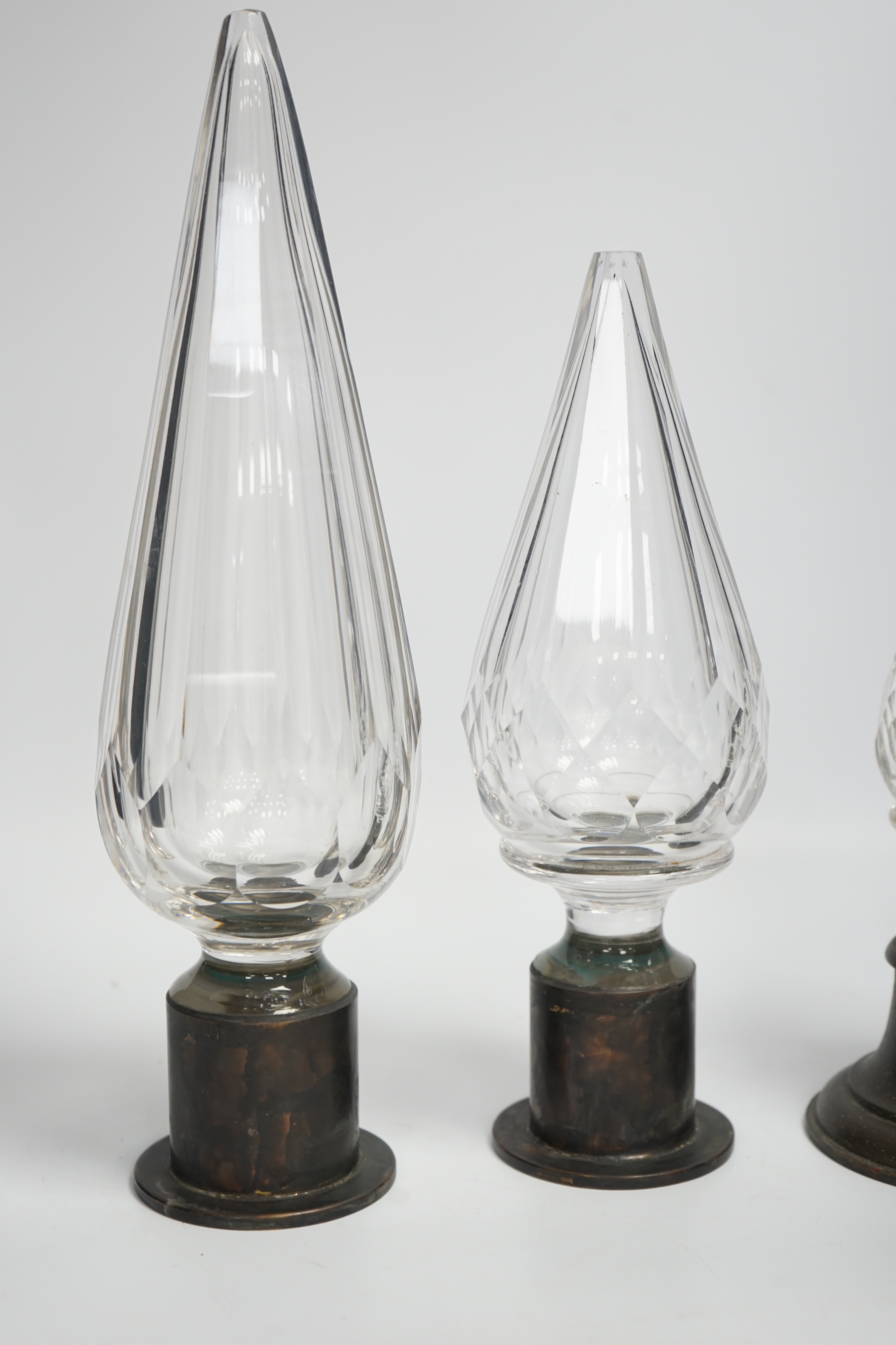 Three Large cut glass stoppers mounted on brass bases, highest 32.5cm